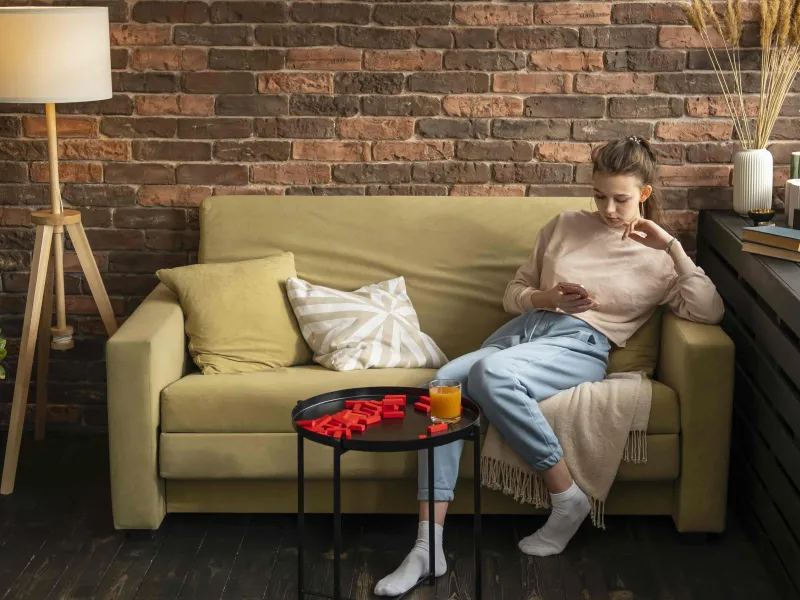 full-shot-woman-sitting-couch-min.jpg