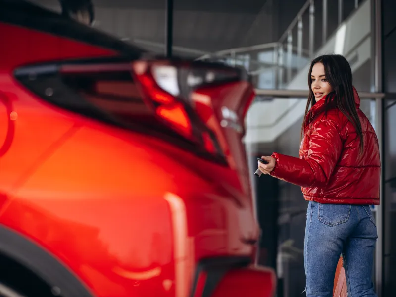 woman-standing-by-her-new-red-car-min.jpg