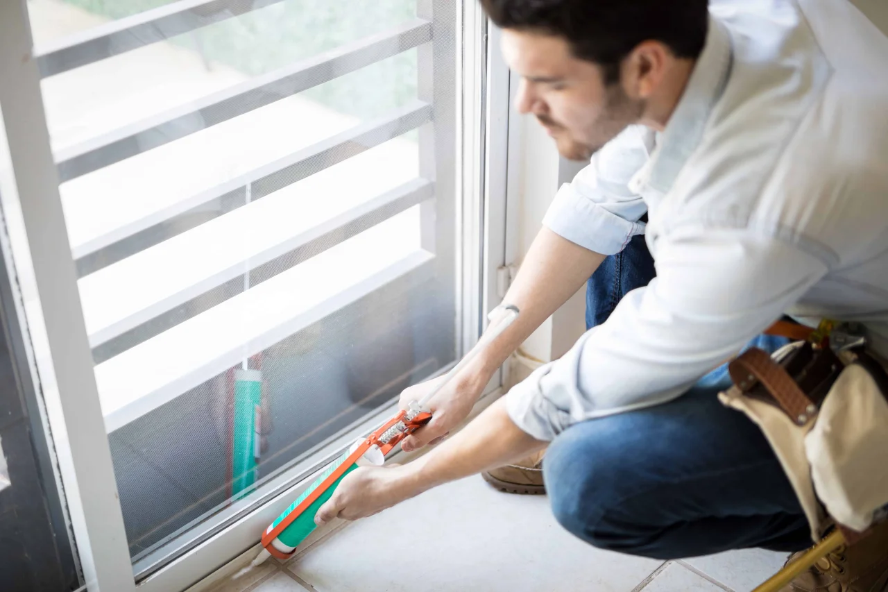 closeup-young-handyman-applying-some-sealant-door-with-sealing-gun-min